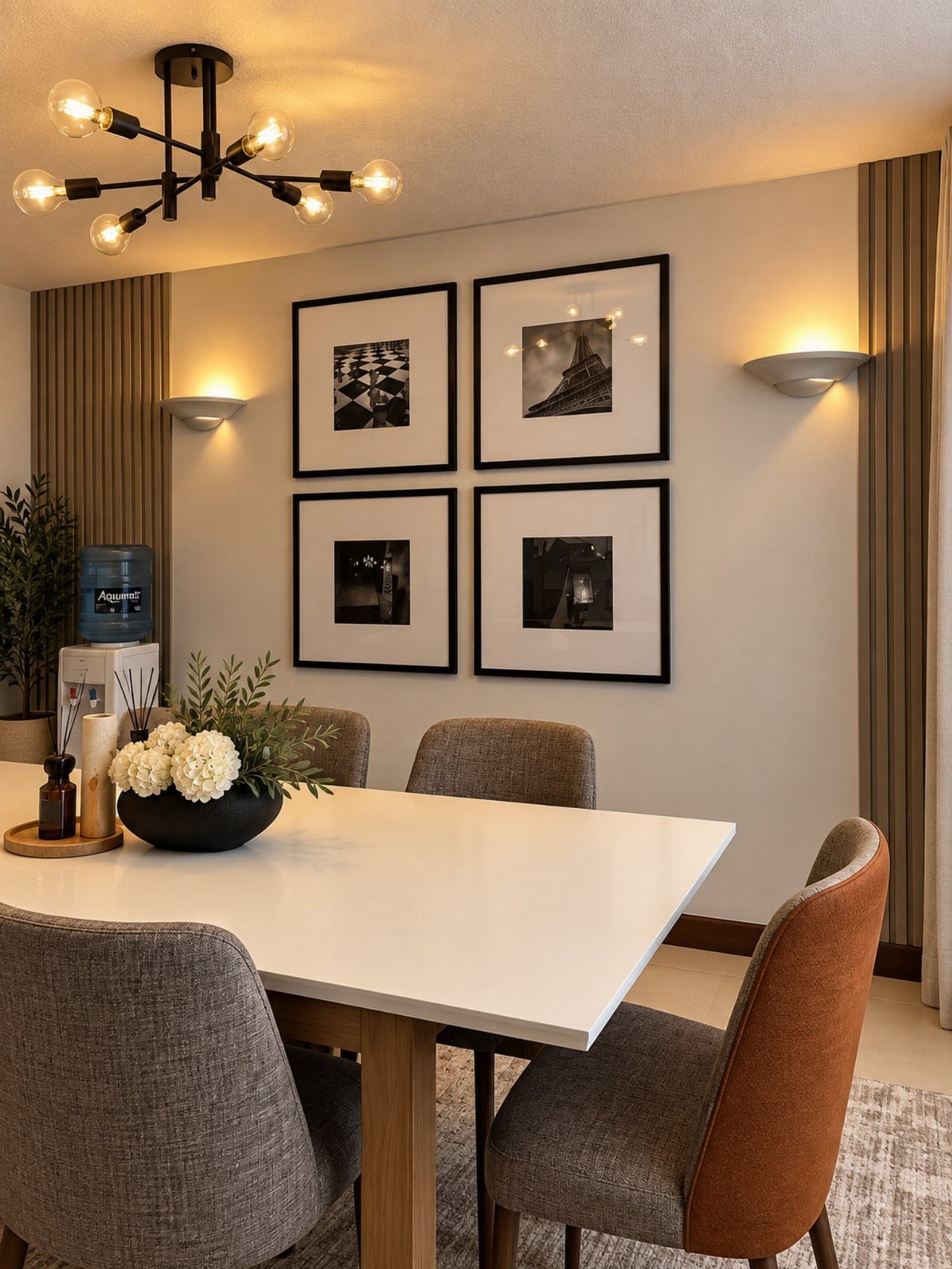 A modern dining room with white table, grey chairs, and black framed art on the wall.