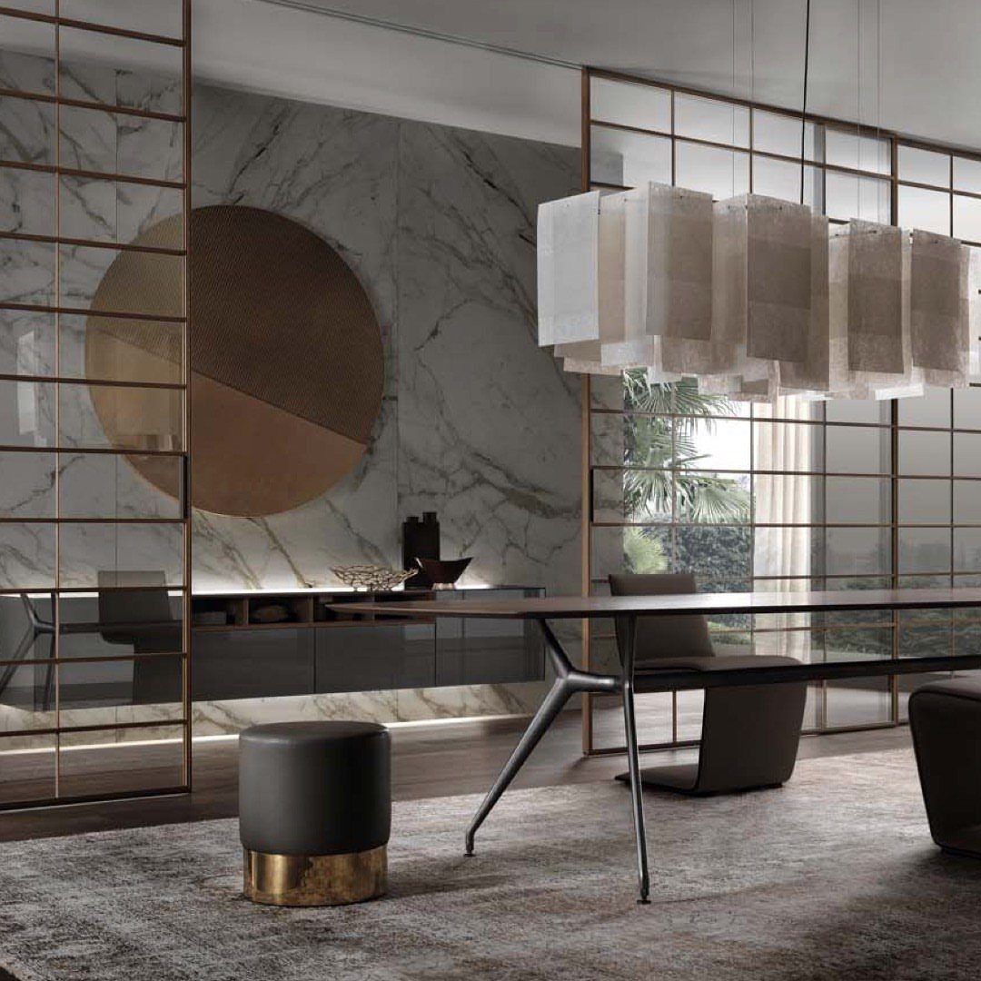 Contemporary dining room with marble walls, dark furniture, and large bronze-framed glass doors.