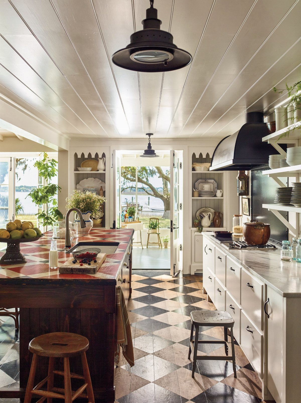 A bright farmhouse kitchen featuring black and white checkered tile flooring and white cabinetry.