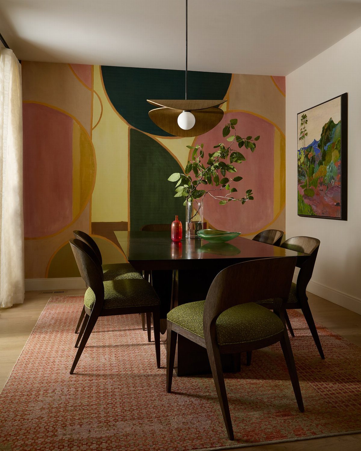 Dining room with dark table, green chairs, patterned rug, and large abstract wall mural.