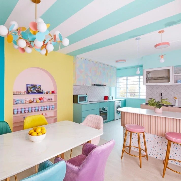 Eclectic dining room with pastel furniture, striped ceiling, and a bright yellow arched alcove.