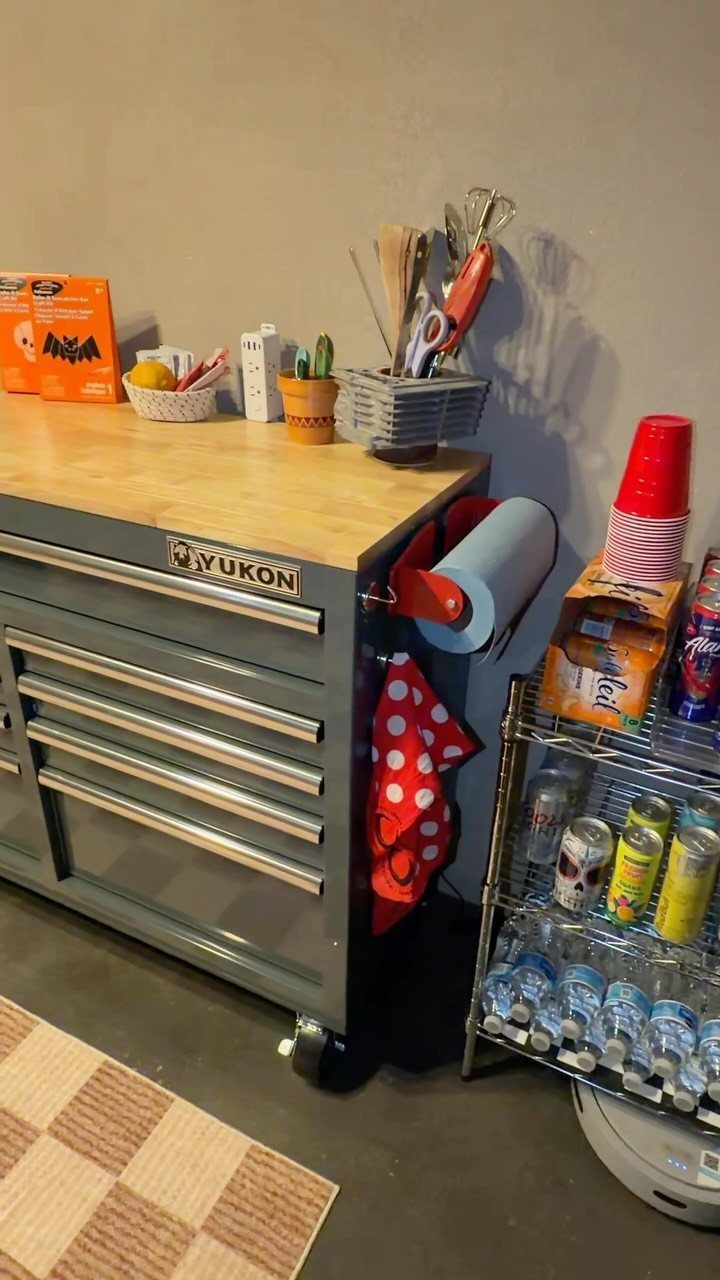 A wooden tabletop mounted on a grey rolling tool chest in a workshop.