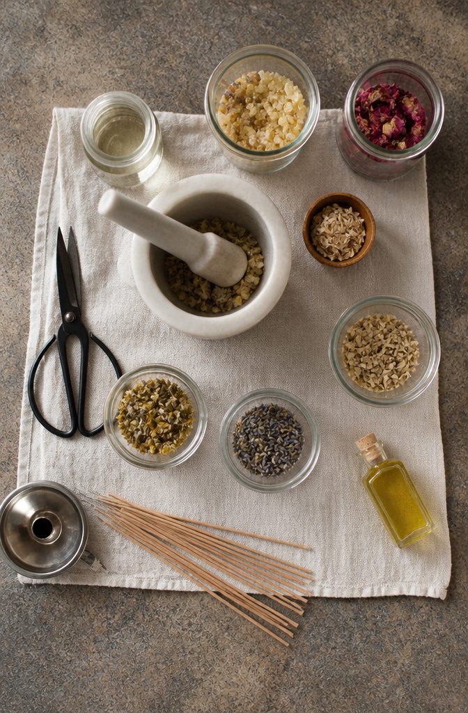 Mortar, pestle, scissors, and glass containers on a workspace.