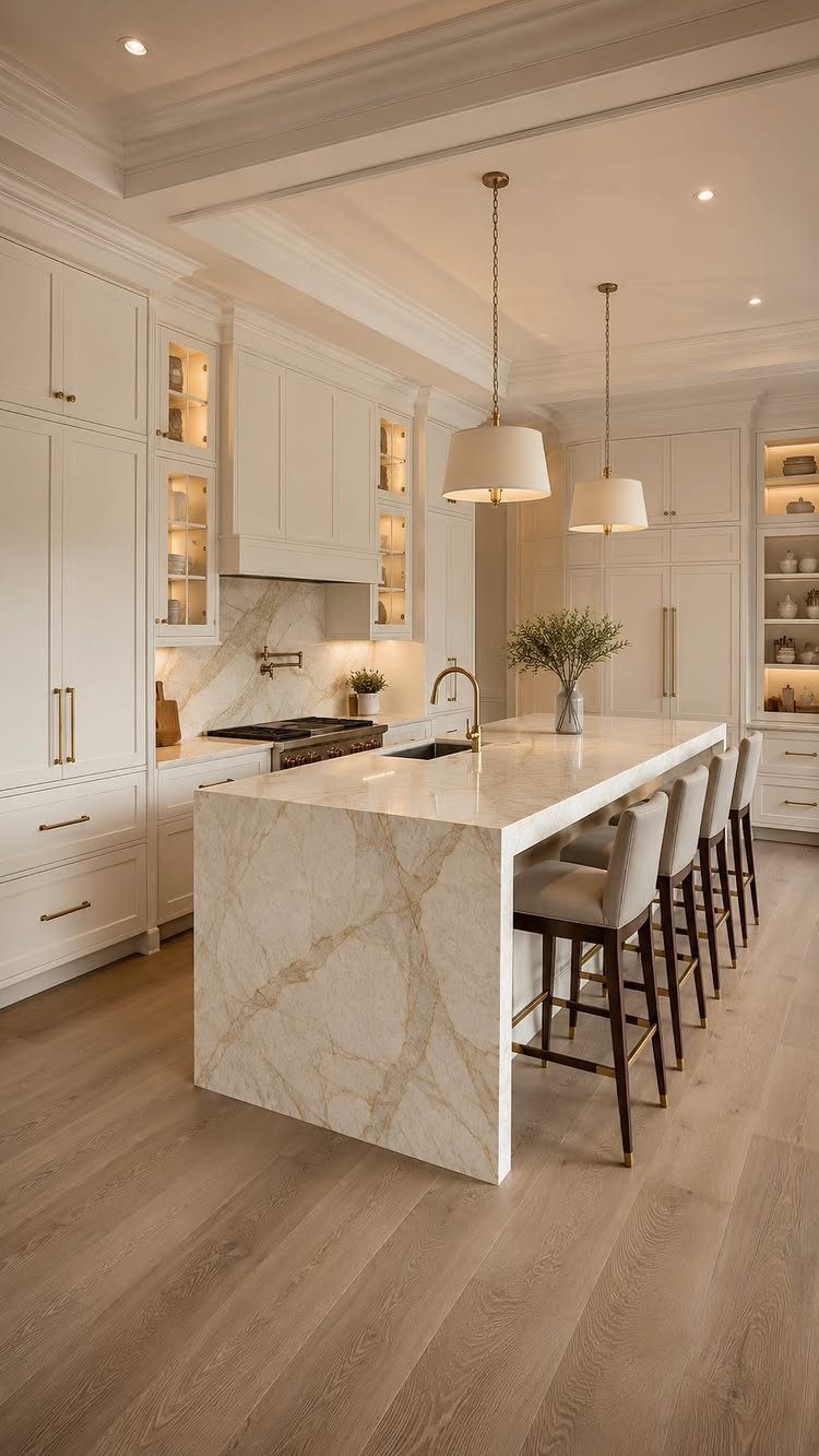 White shaker cabinets and a marble waterfall island in a bright, modern kitchen setting.