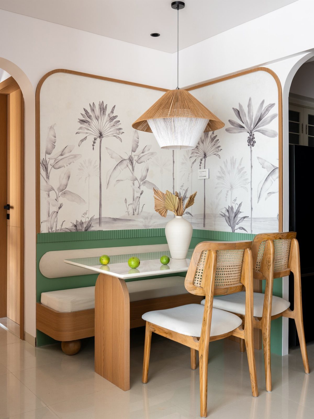 Dining nook with a marble table, wooden cane chairs, and a large woven pendant light.
