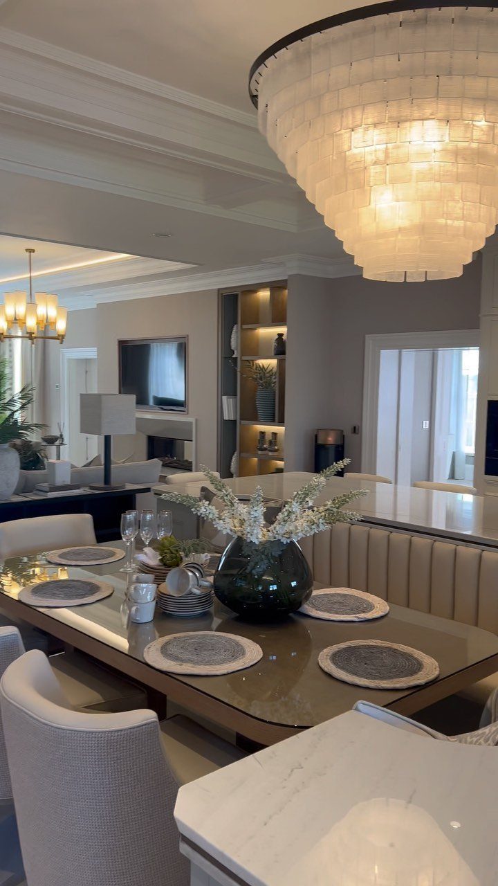 Dining table set with placemats and flowers in a modern open floor plan living space.