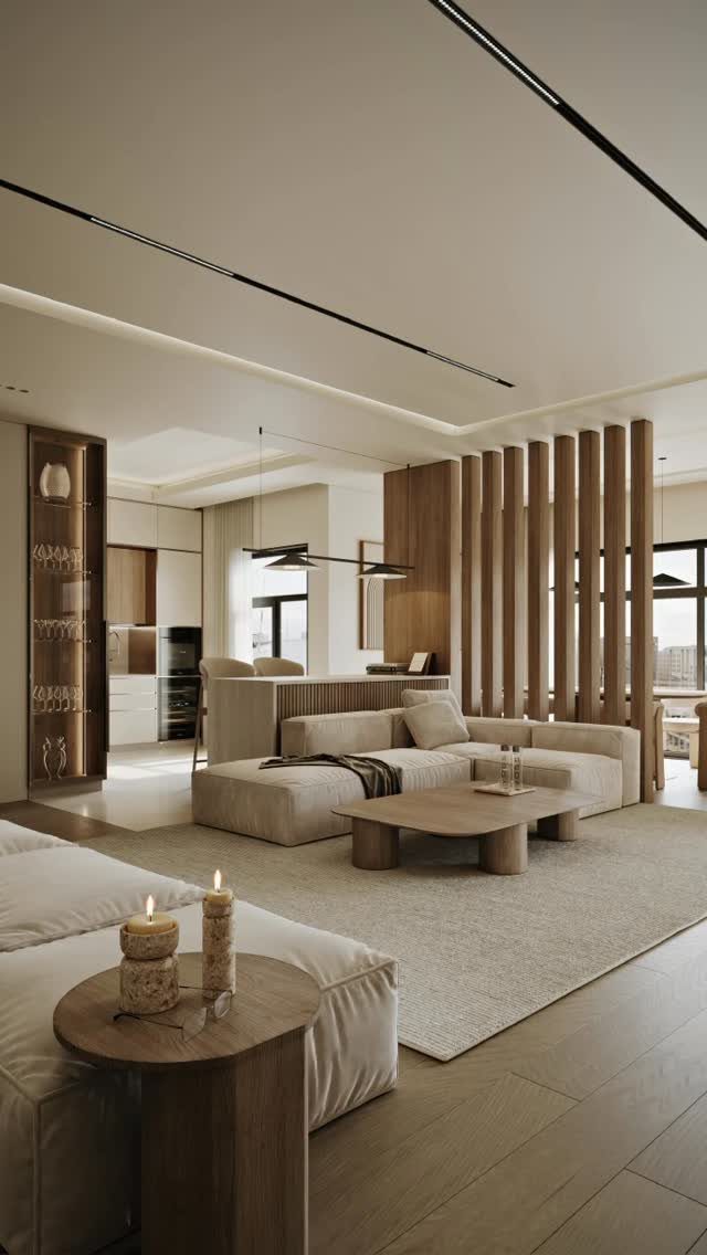 Modern open-concept living room with a beige sofa, wooden coffee table, and kitchen area in background.