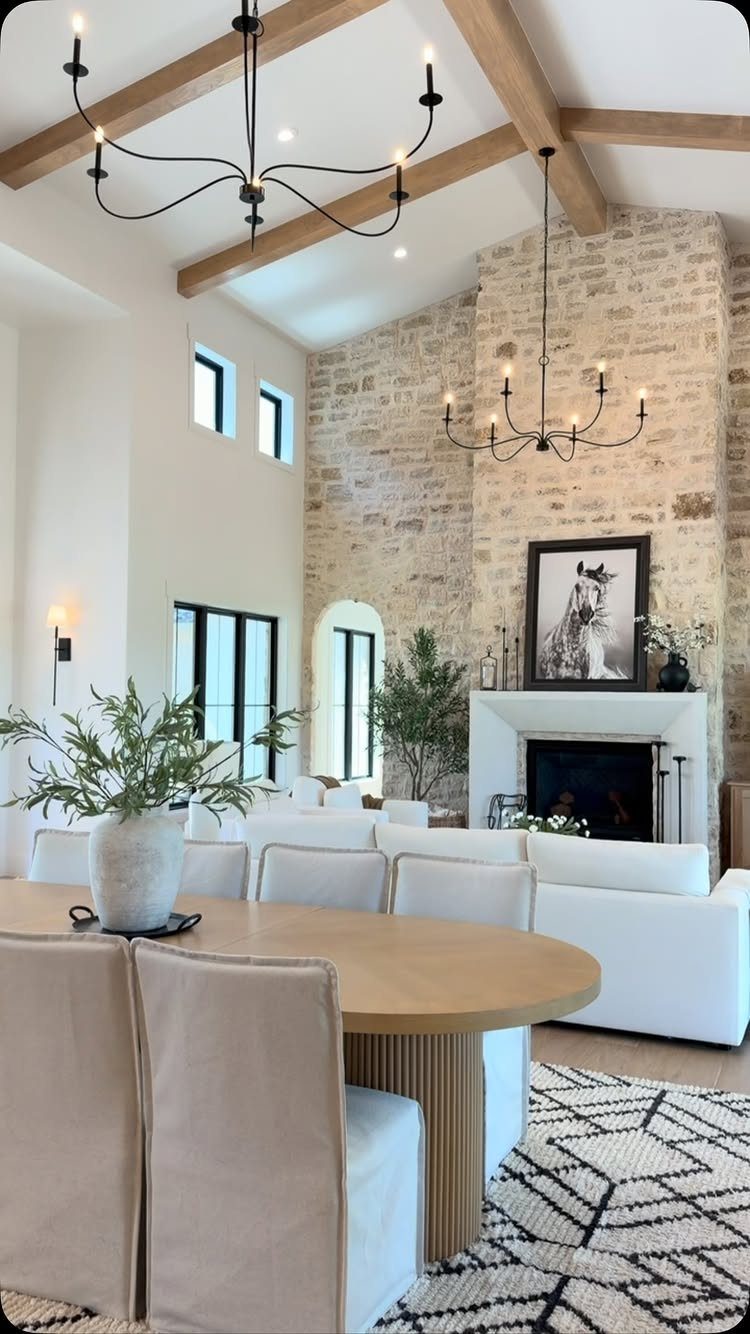 Cream upholstered chairs surround a light wood oval dining table in a bright room.