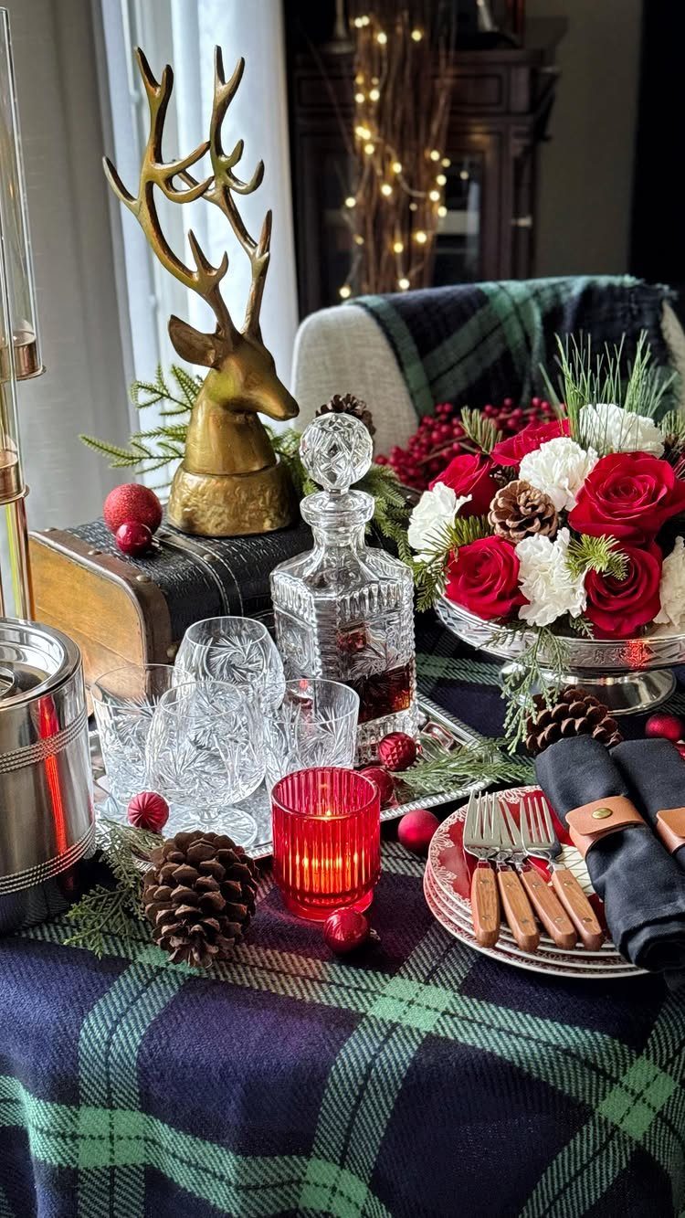 Crystal decanter and glasses set on a plaid tablecloth with festive holiday decorations.