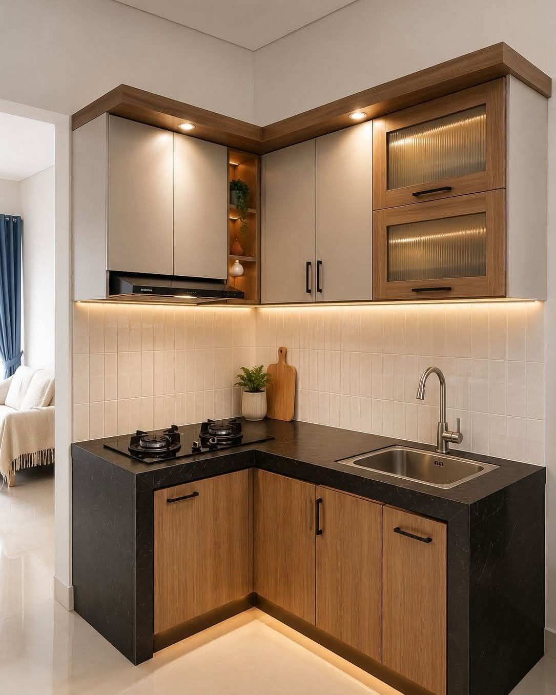 L-shaped kitchen with grey upper cabinets, wood lower cabinets, and black countertops.